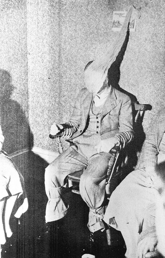 Jack Webber, medium, is tied to a chair, ectoplasma covering his face and drifting upward to the wall - from Edwards' "The Mediumship of Jack Webber" (1941)